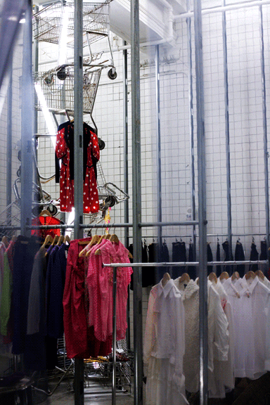 Clothes hang from shopping trolleys and industrial-style metal grids Clothes hang from shopping trolleys and industrial-style metal grids
