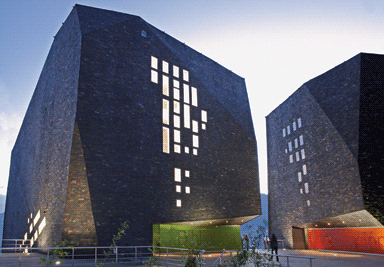 The facade combines local black slate and coloured glass